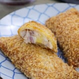 crispy tuna pocket pies showing filling on a serving plate.