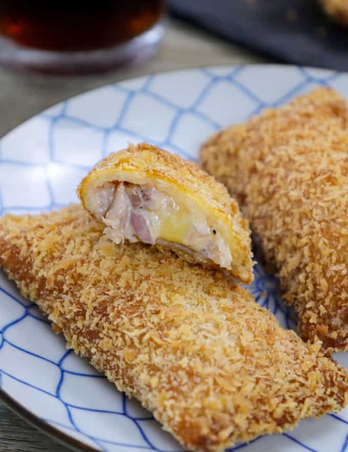 crispy tuna pocket pies showing filling on a serving plate.