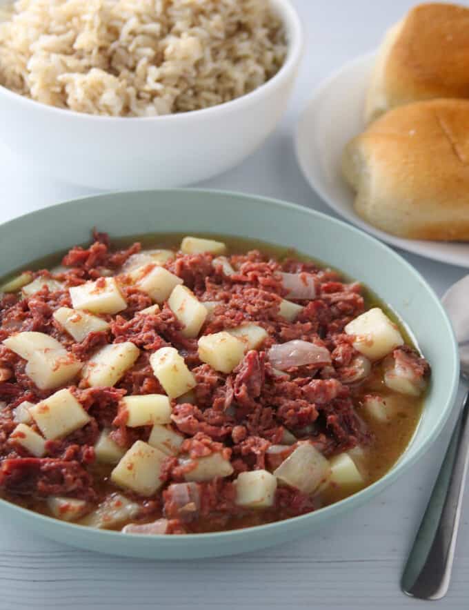 Ginisang Corned Beef in a serving bowl with pandesal and steamed rice on the side