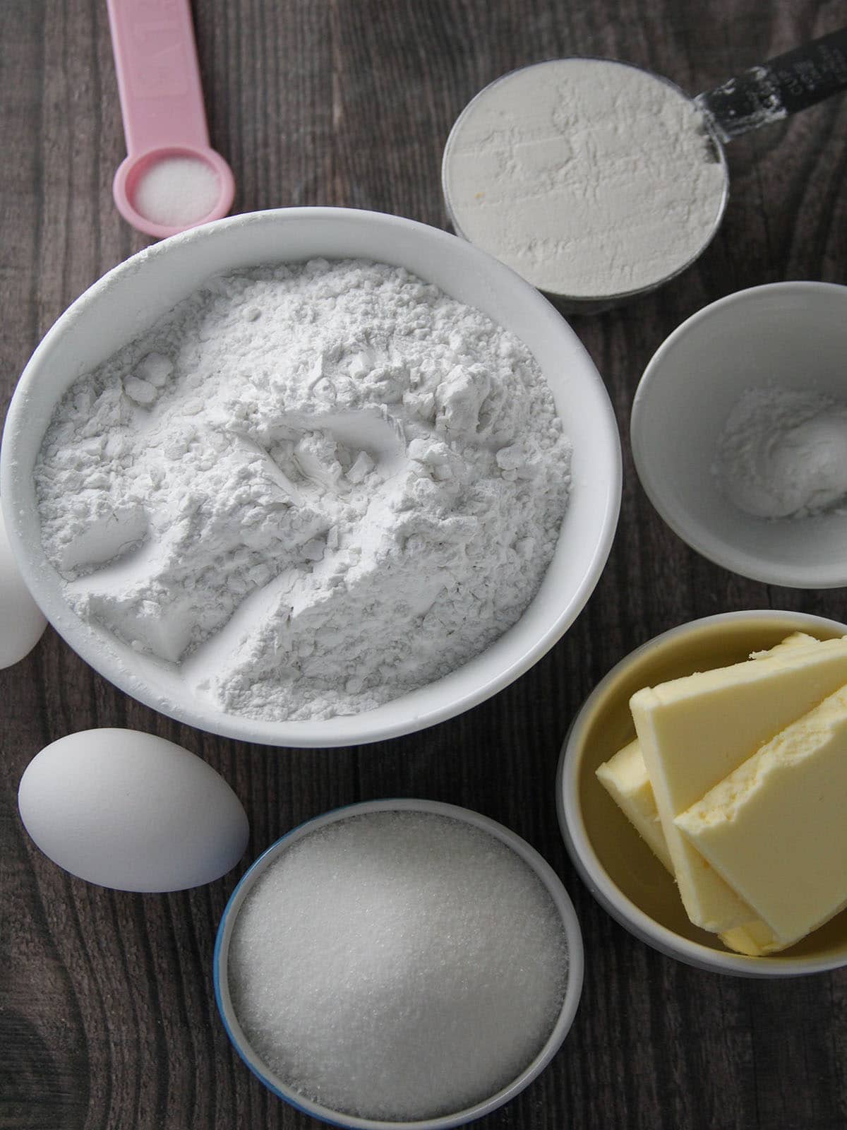 Arrowroot flour, butter, sugar, eggs, baking powder, and flour in individual bowls
