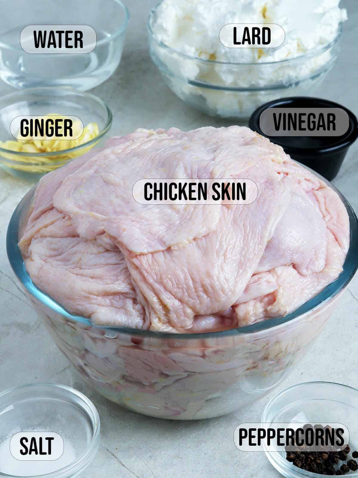 chicken skins, garlic, peppercorns, vinegar, water, lard in bowls.