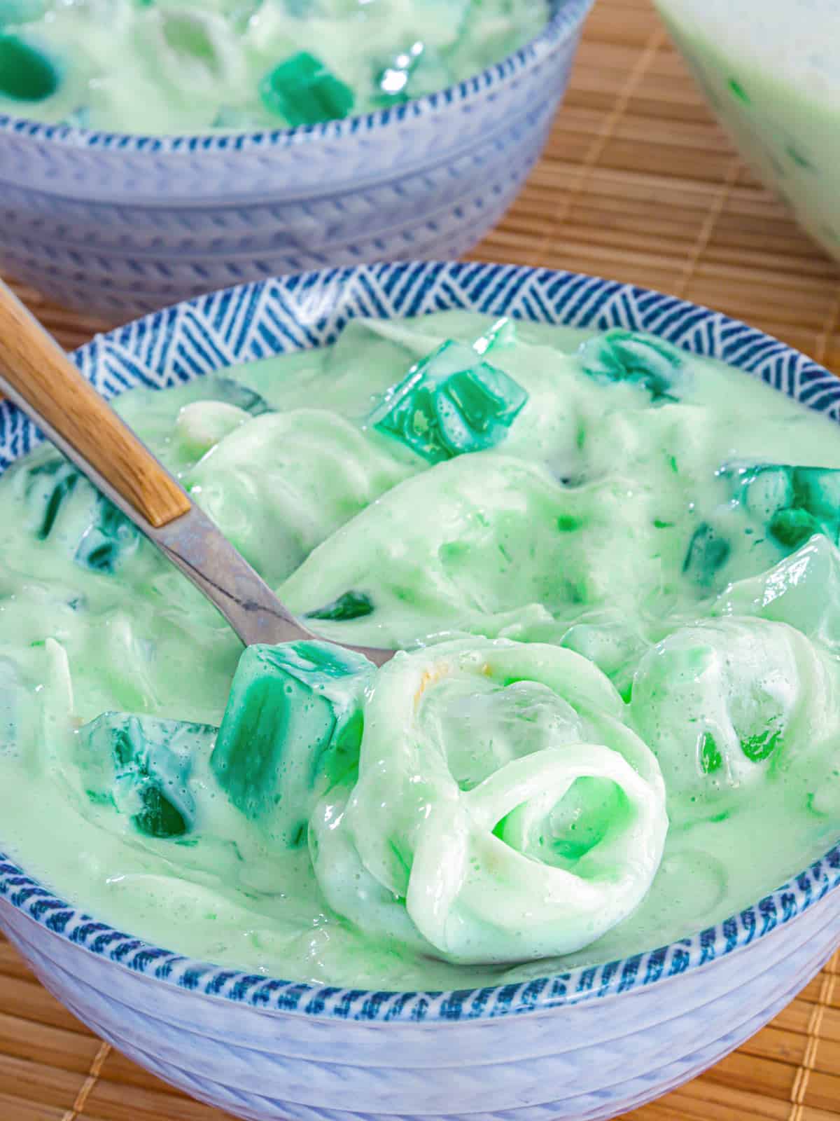 buko pandan salad in a blue bowl with a spoon for eating.