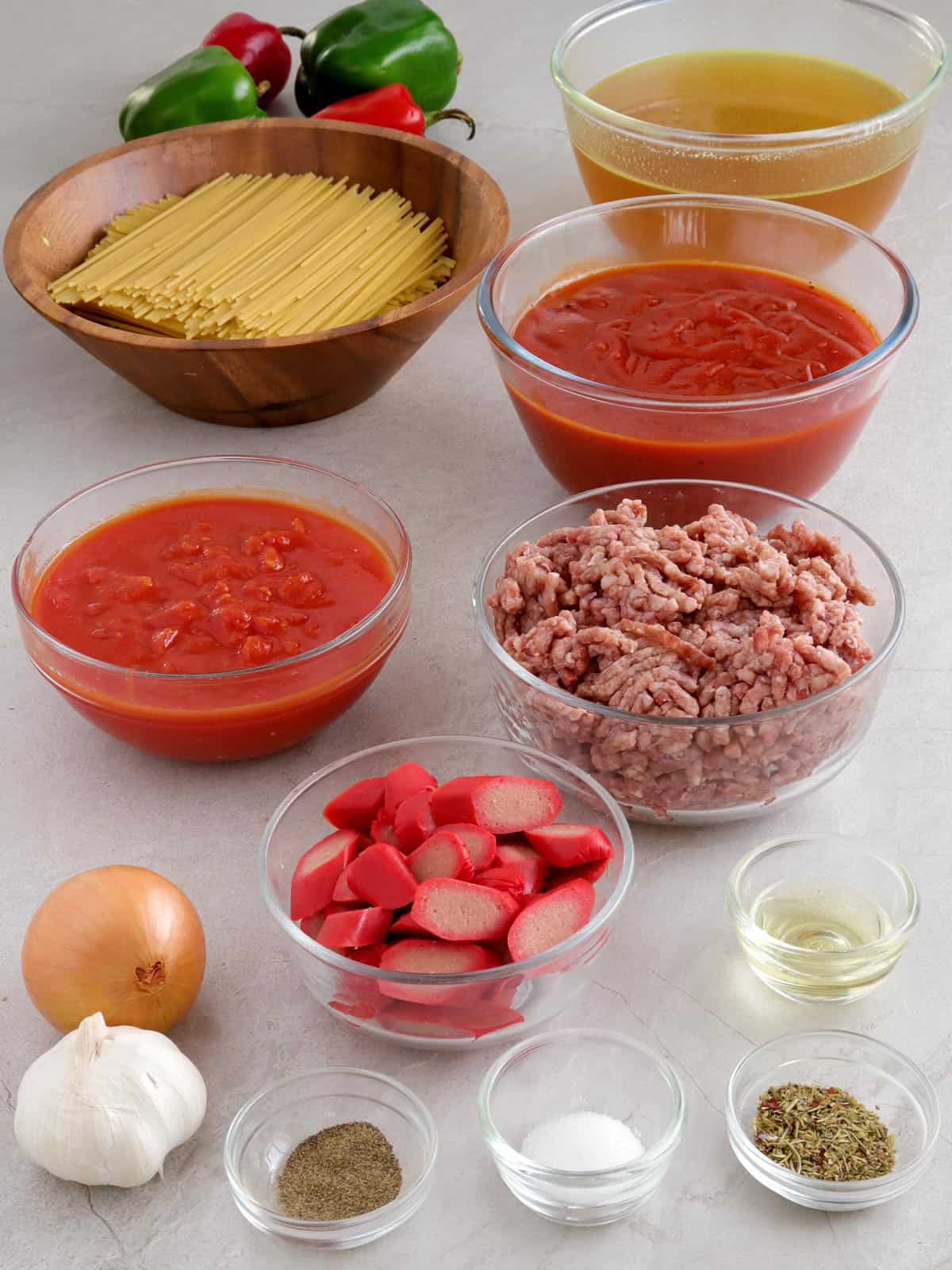 spaghetti, ground beef, ketchup, diced tomatoes, hot dogs, onion, garlic, salt, pepper, oil, broth, bell peppers in bowls