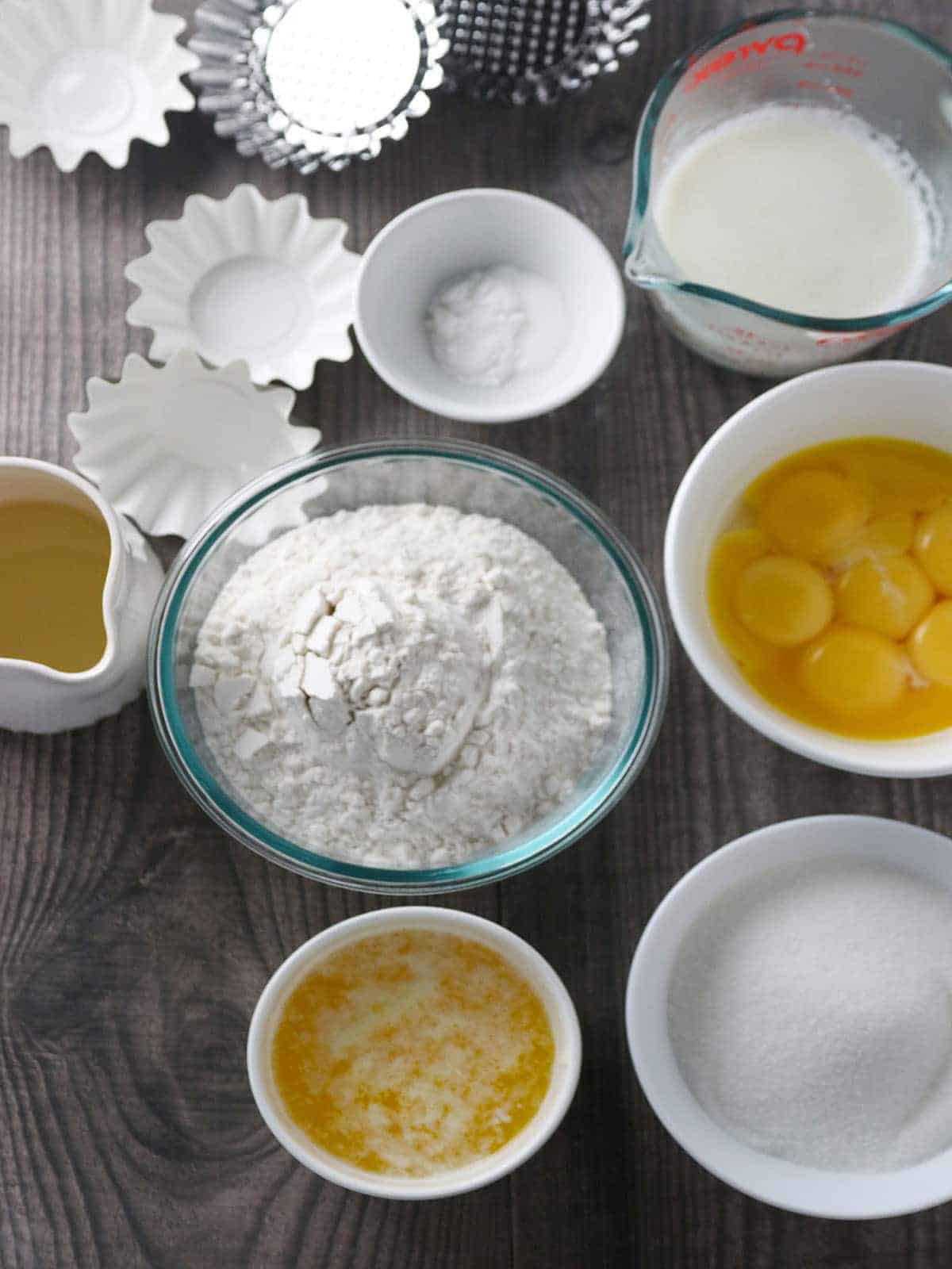 flour, egg yolks, melted butter, sugar, baking powder, muffin tin, milk, oil