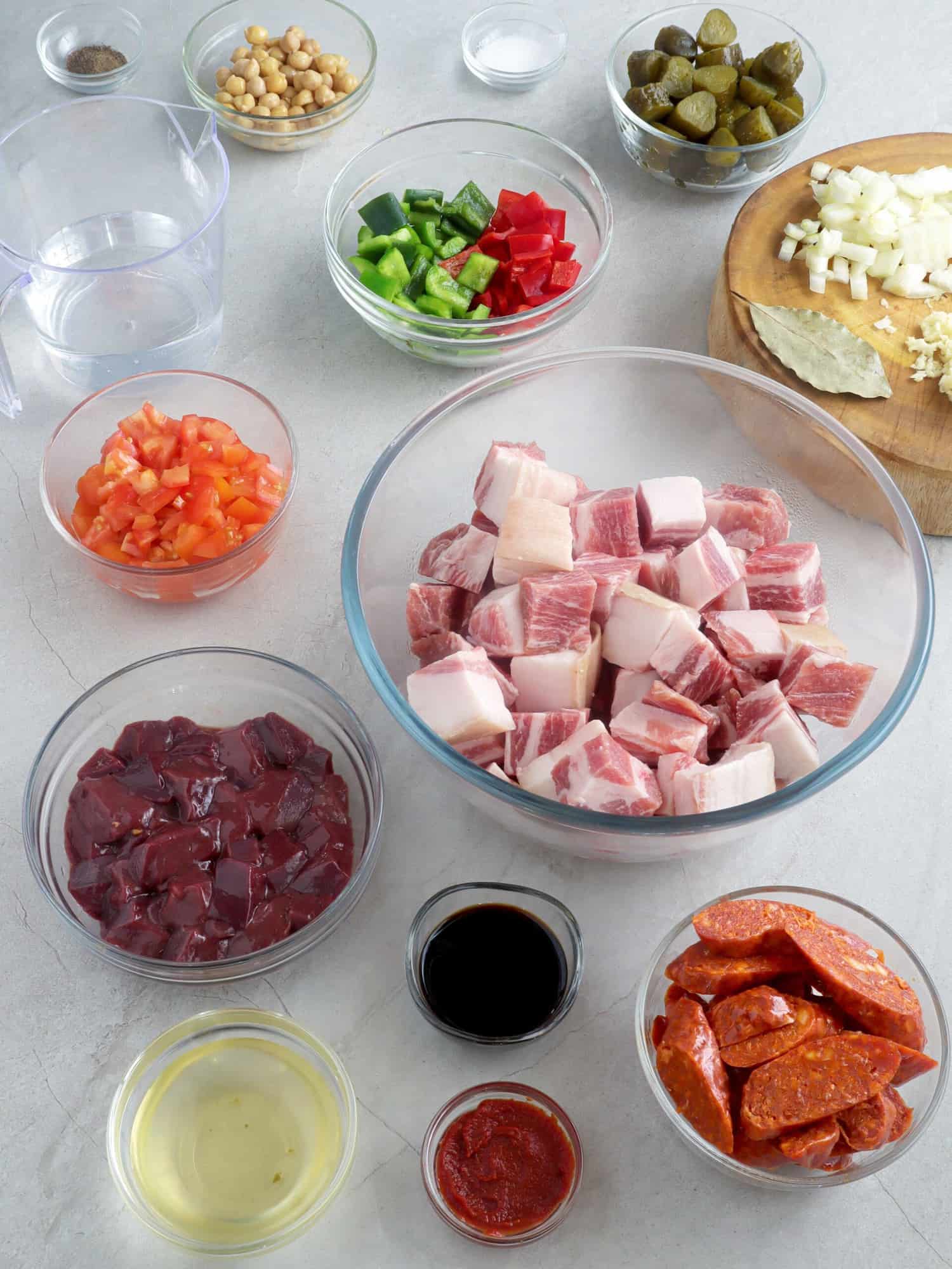 pork cubes, liver, bell peppers, tomatoes, chorizo, oil, soy sauce, tomato paste in bowls