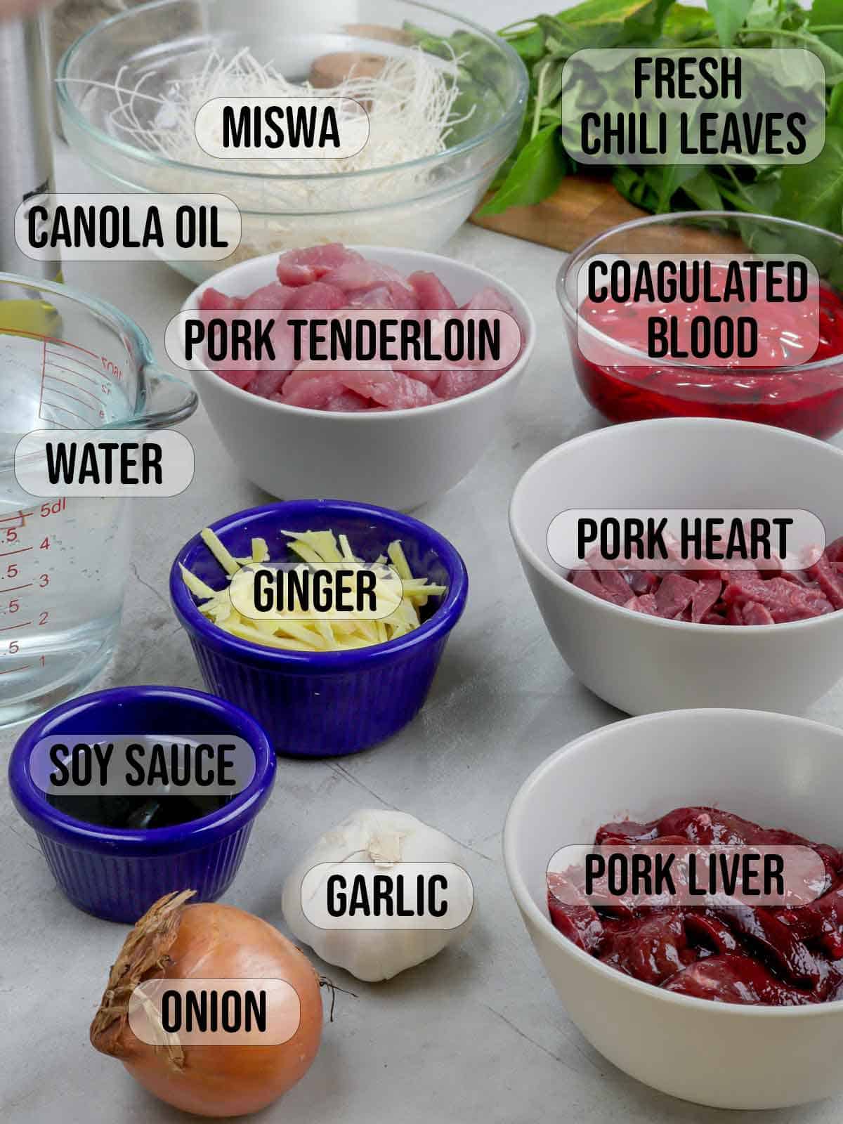 pork, pork heart, liver, miswa, blood, onion, garlic, spinach, water, ginger, fish sauce in bowls.