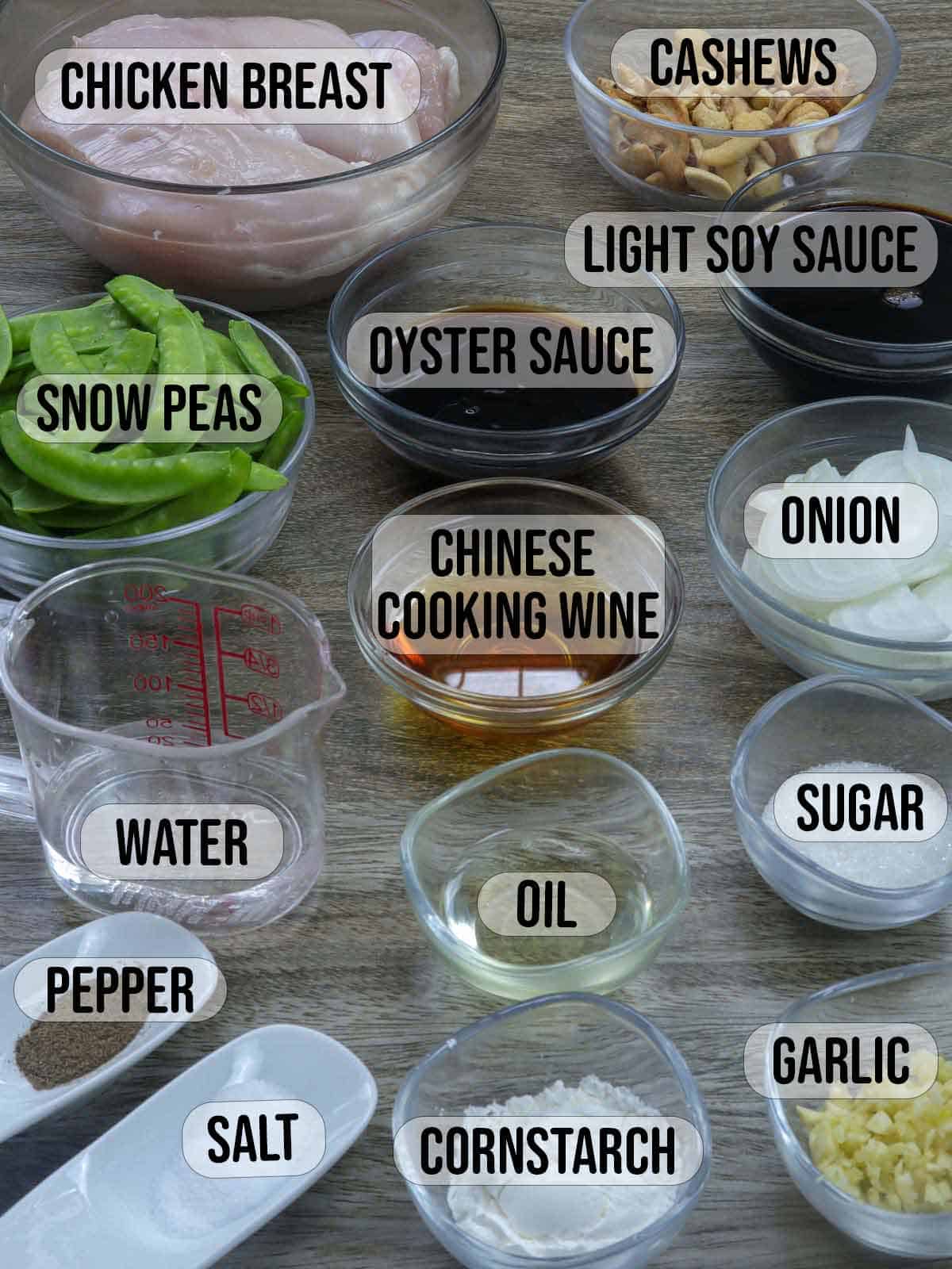 chicken, cashews, snow peas, oyster sauce, soy sauce, Chinese cooking wine, garlic, onions, salt, pepper, oil, water in bowls