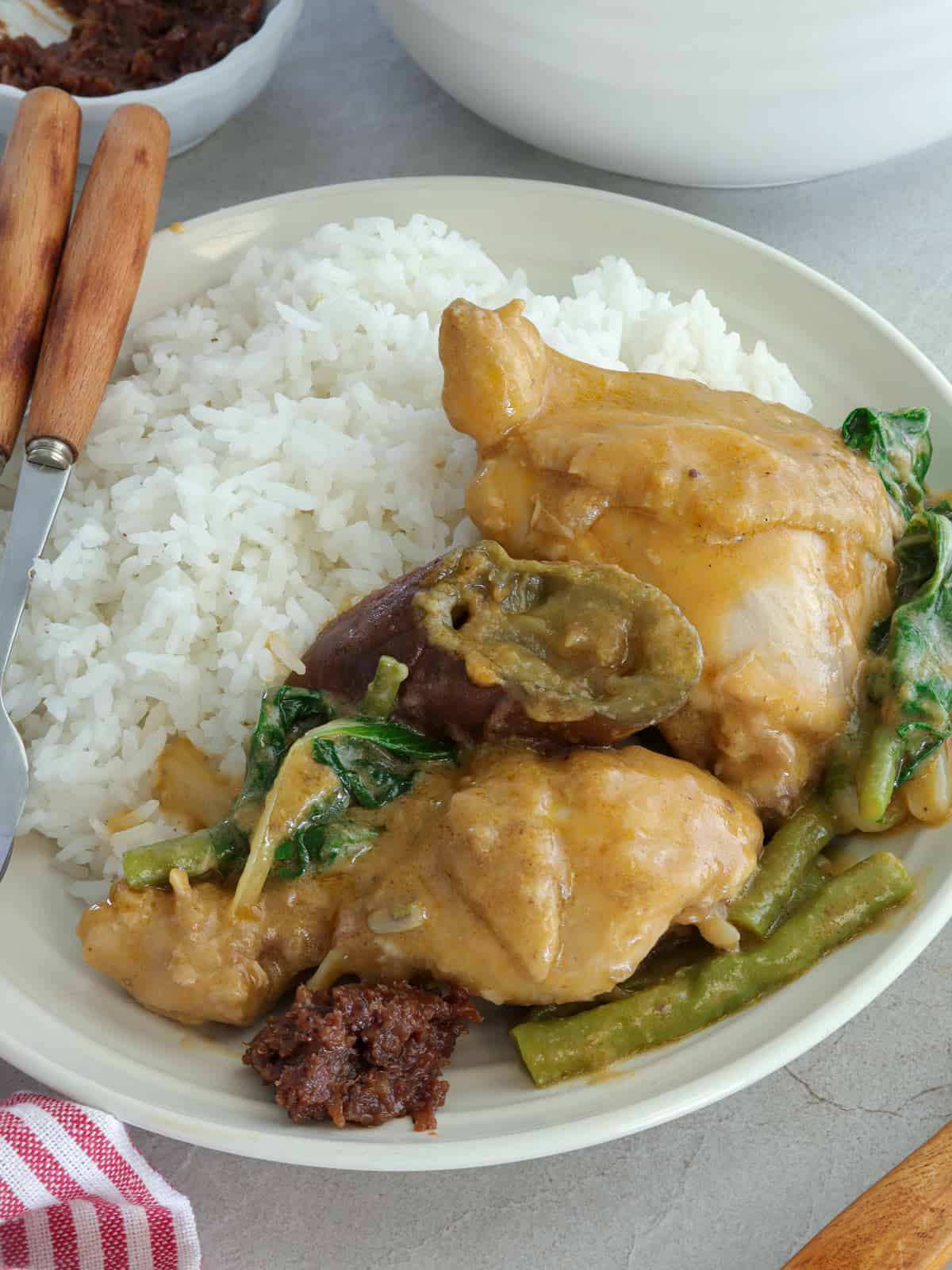 kare-kareng manok on a white plate with steamed rice and ginisang bagoong.