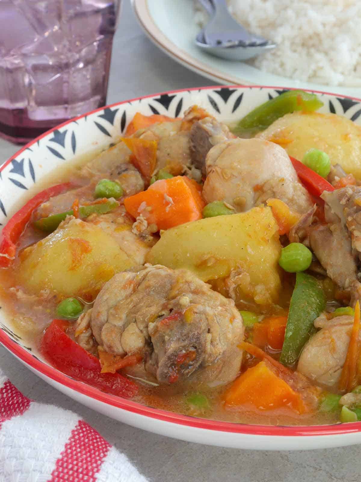 Chicken Afritada in a white serving bowl.