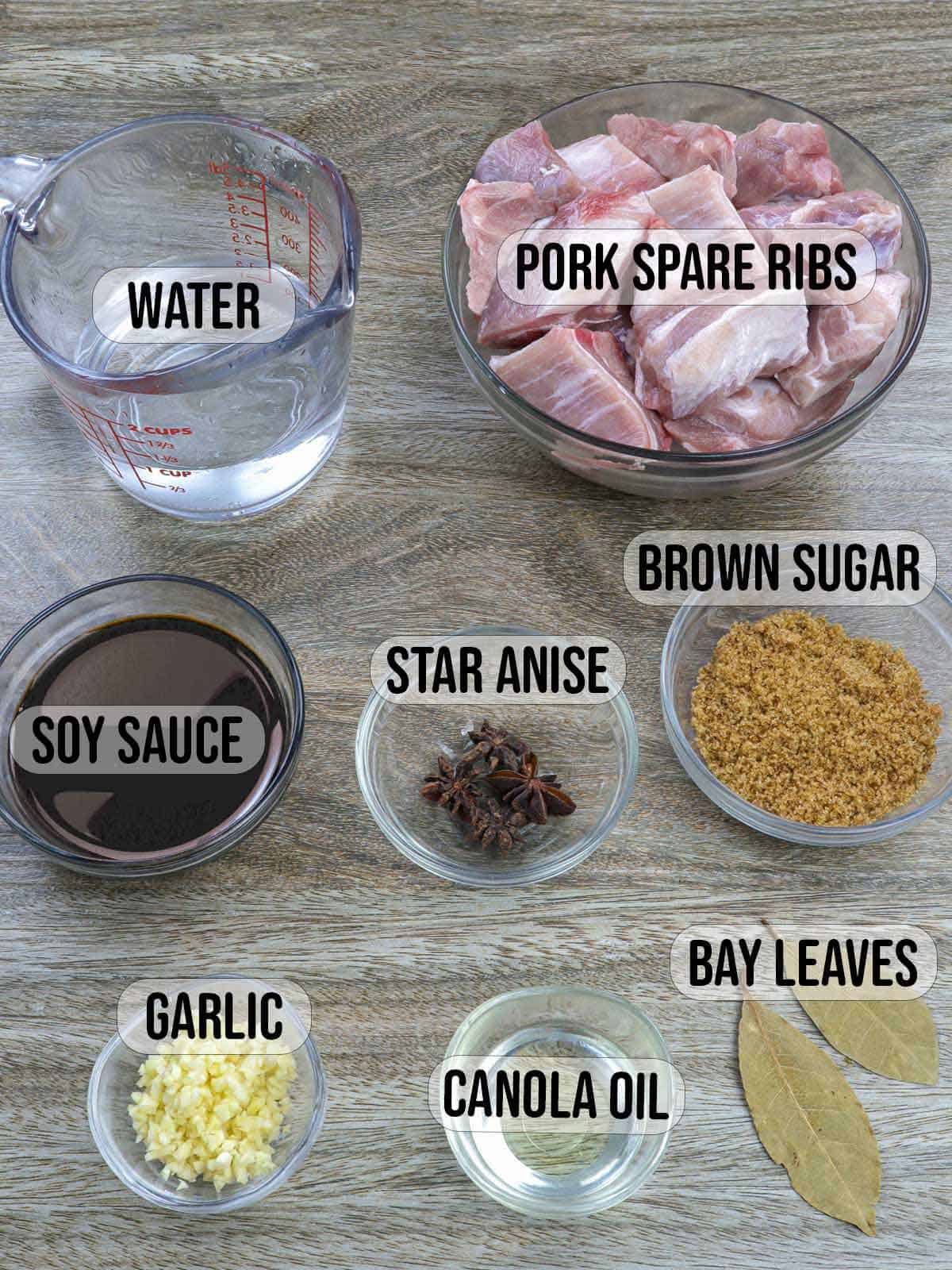 pork spareribs, brown sugar, soy sauce, bay leaves, star anise in bowls.