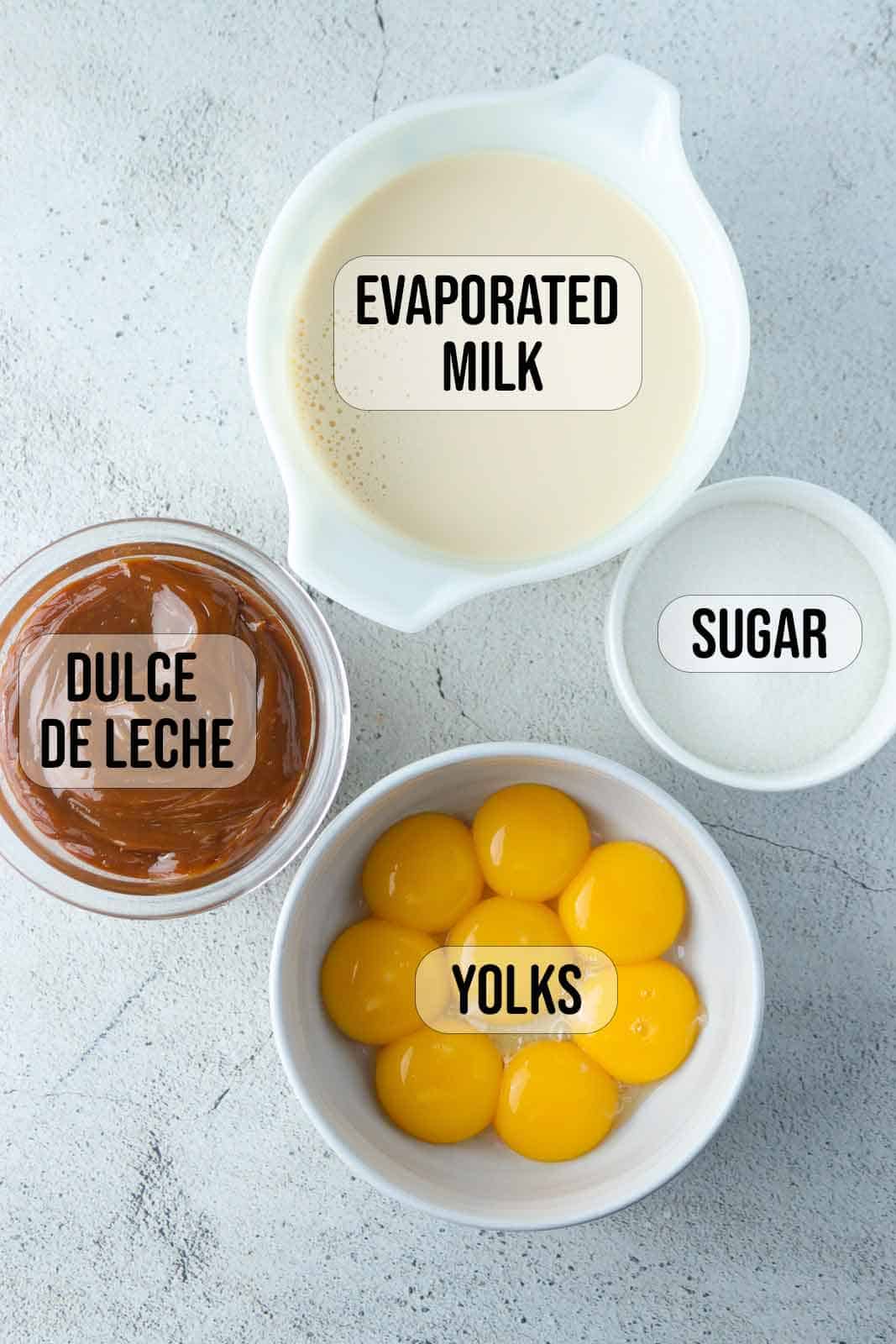 egg yolks, evaporated milk, sguar, dulce de leche in bowls.