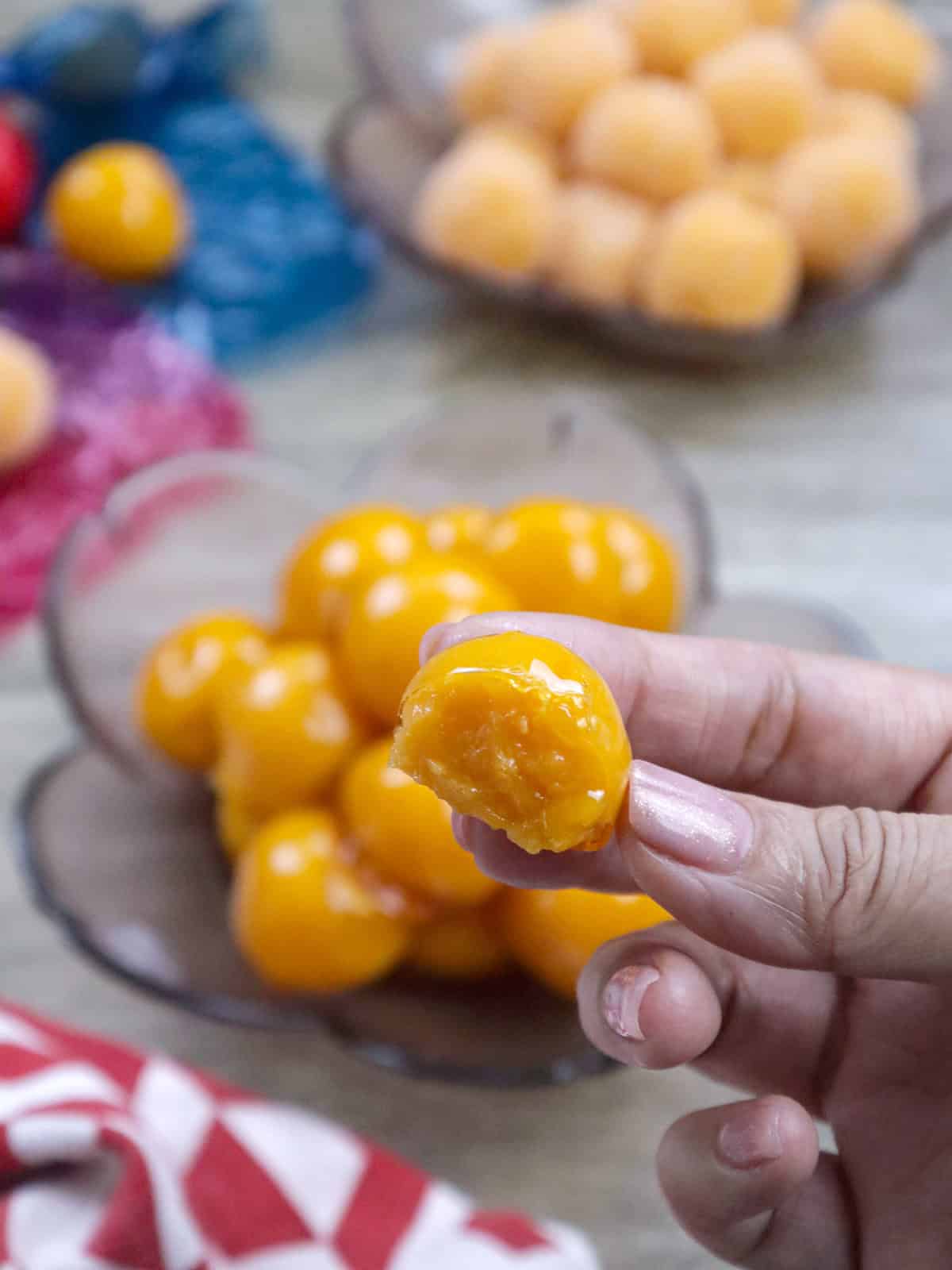 laikanti įkandusį yemos saldainių rutulį, padengtą karamelės lukštu.