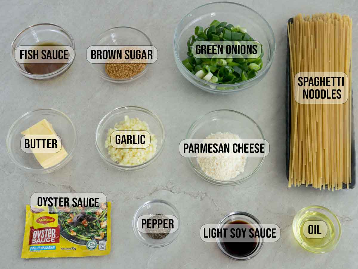 spaghetti, soy sauce, oyster sauce packet, fish sauce, brown sugar, parmesan cheese, green onions, garlic, butter, oil in bowls.